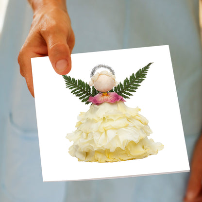 Hand holding the Christmas Cream Angel greeting card, showing the cream flower angel design