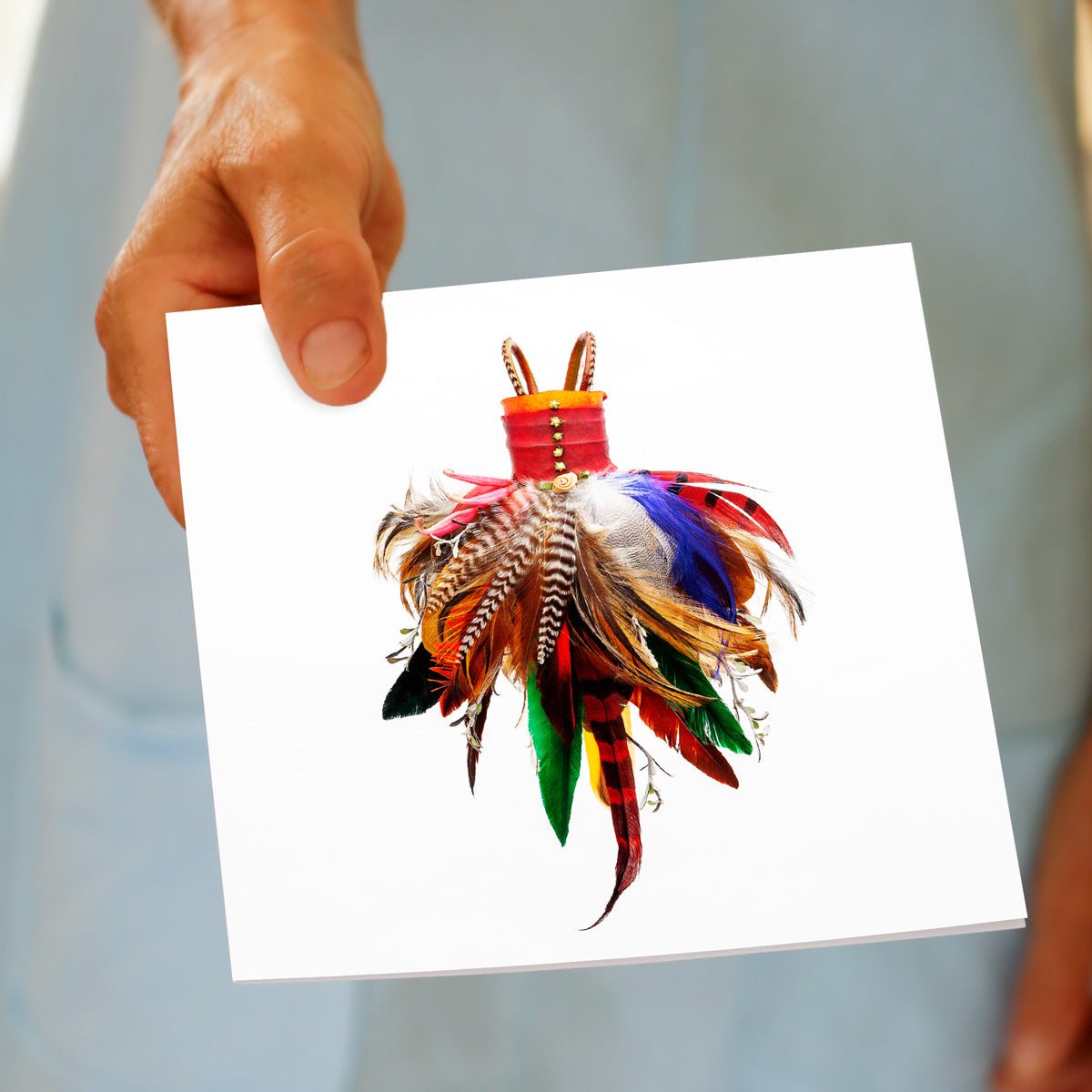 A feather dress greeting card being hand held by a model. Available from Golly Gosh Creations. Size 142 x 142 mm