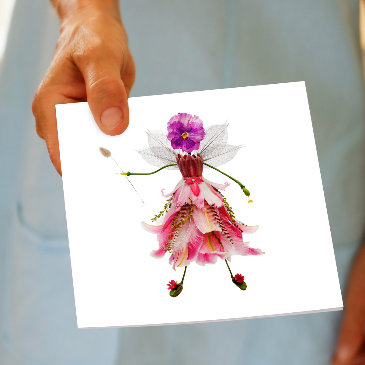 A hand held enchanting flower fairy greeting card found at Golly Gosh Creations. Created from dainty pink and pastel blooms. Size 142 x 142 mm