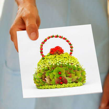 A hydrangea petal bag greeting card being held by hand. Created from lush green hydrangea petals. Available from Golly Gosh Creations. Size 142 x 142 mm.