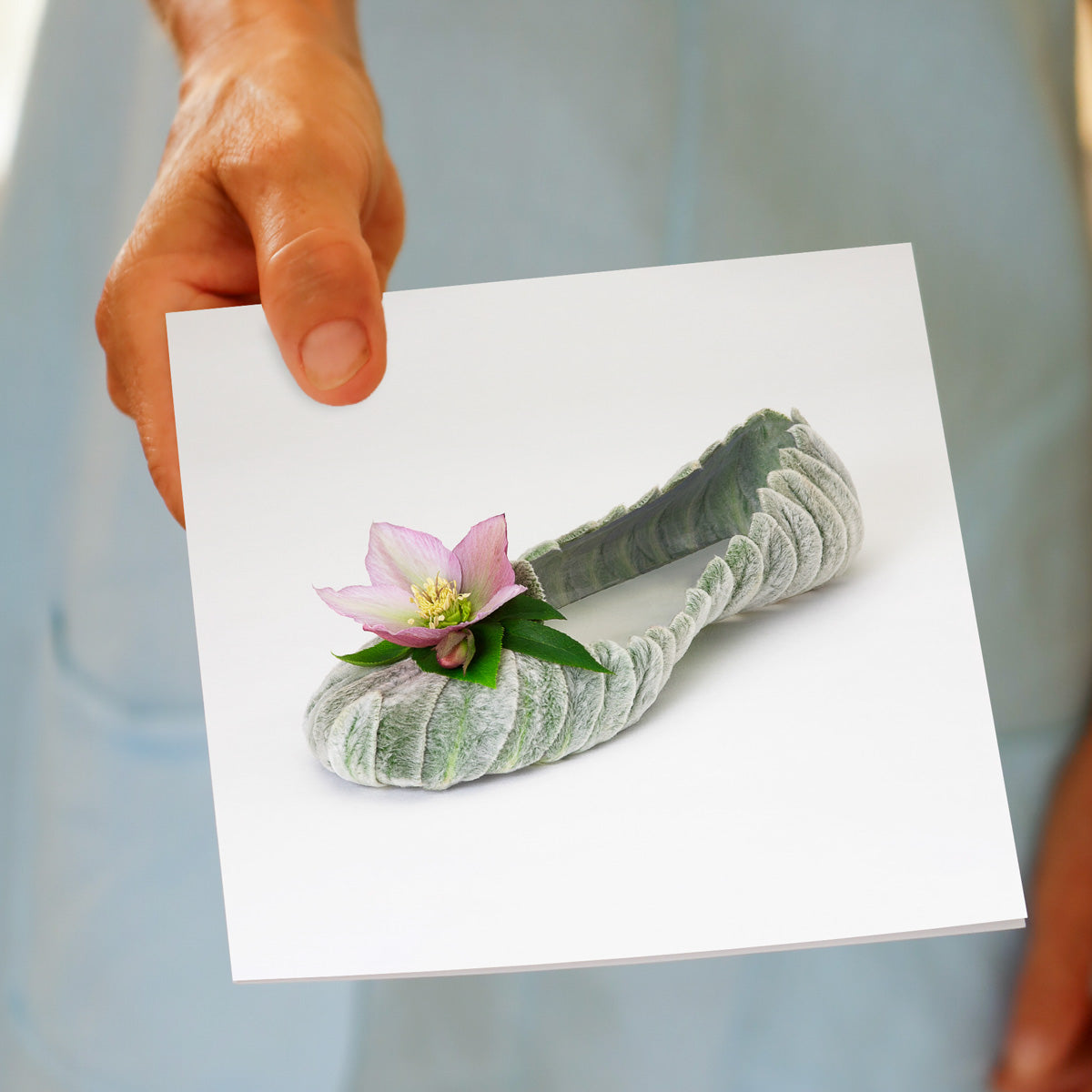 A lambs ear helleborus shoe greeting card being held by hand. Found at Golly Gosh Creations. A generous square card.