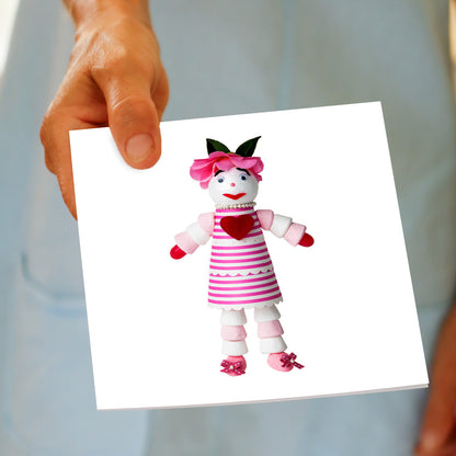 A marshmallow doll greeting card being held by hand from Golly Gosh Creations.
A generous square card created from an assortment of marshmallows.