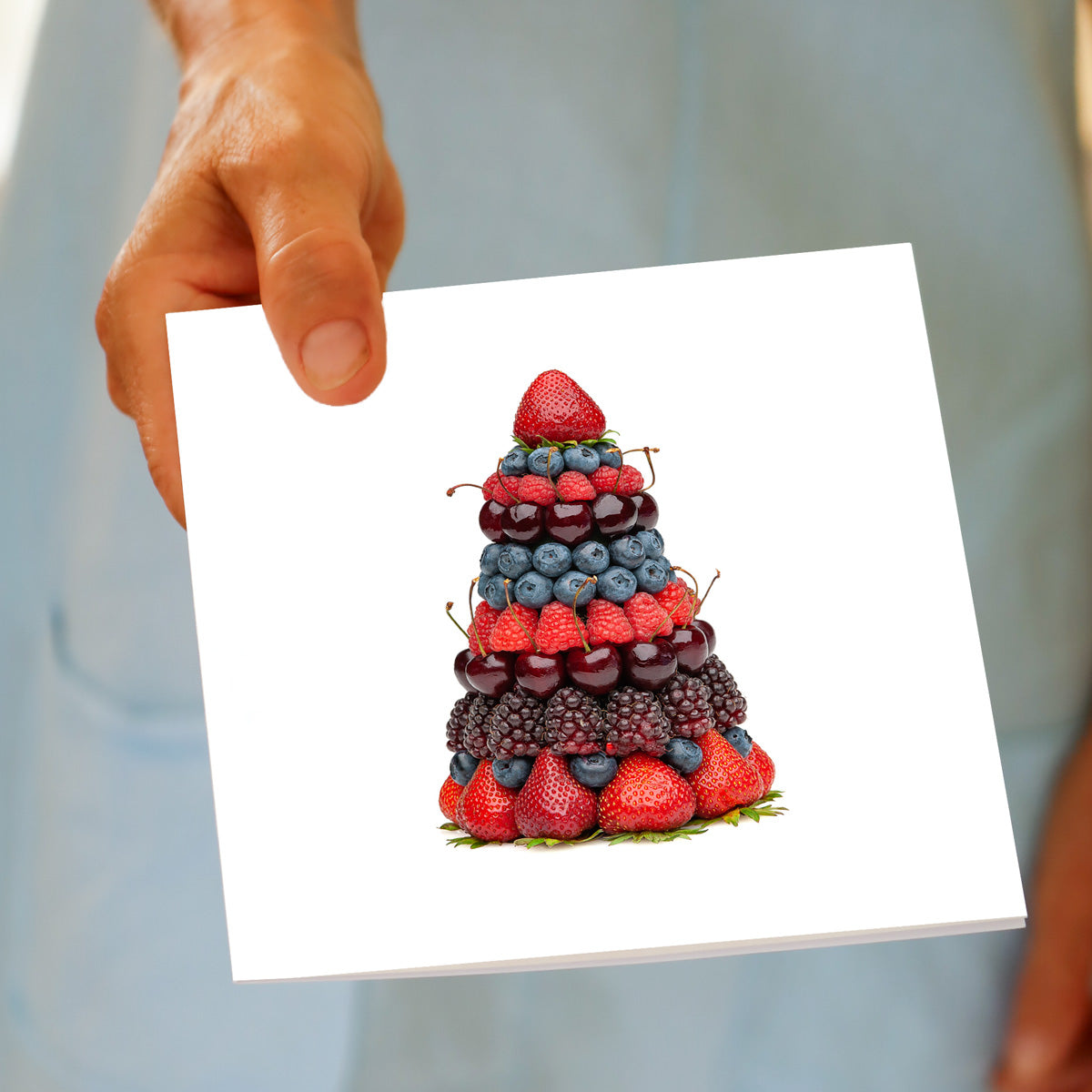Hand holding the Christmas Mixed Berry Stack Tree greeting card, showing the mixed berry design