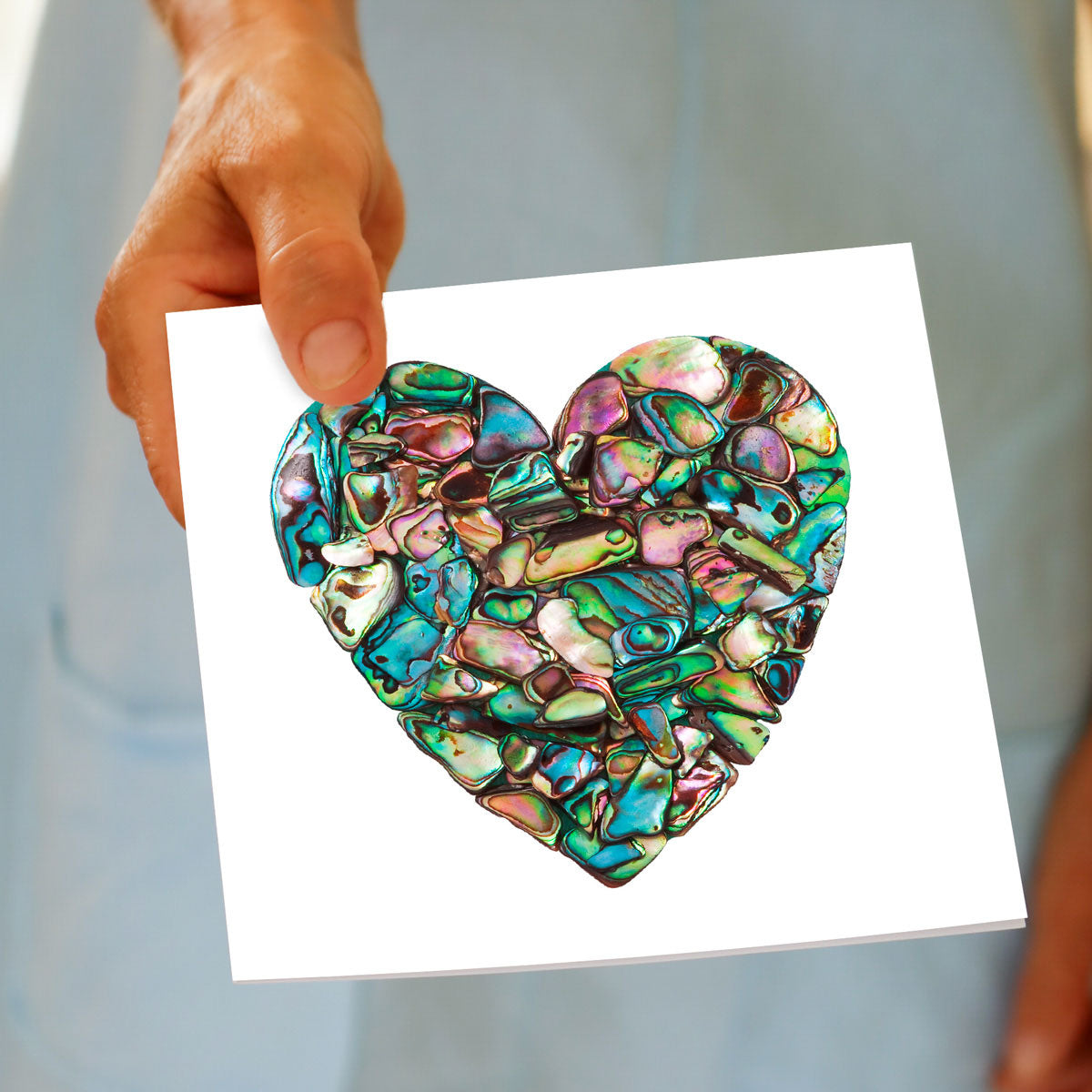 A hand held paua heart greeting card from Golly Gosh Creations. This generous square card is created using pieces of iridescent paua shells.