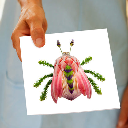 A hand held protea bug greeting card by Golly Gosh Creations. A generous square card created from a pretty pink king protea flower and elongated leaves.